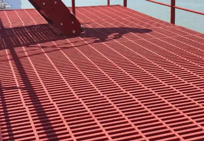 Rød glasfibergitterrist på platform ved vandet