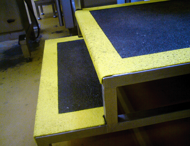 Kundecase - Arla mejeri. Sikring af glatte ståltrin i mejeri med sort og gult anti skrid underlag på overfladen.