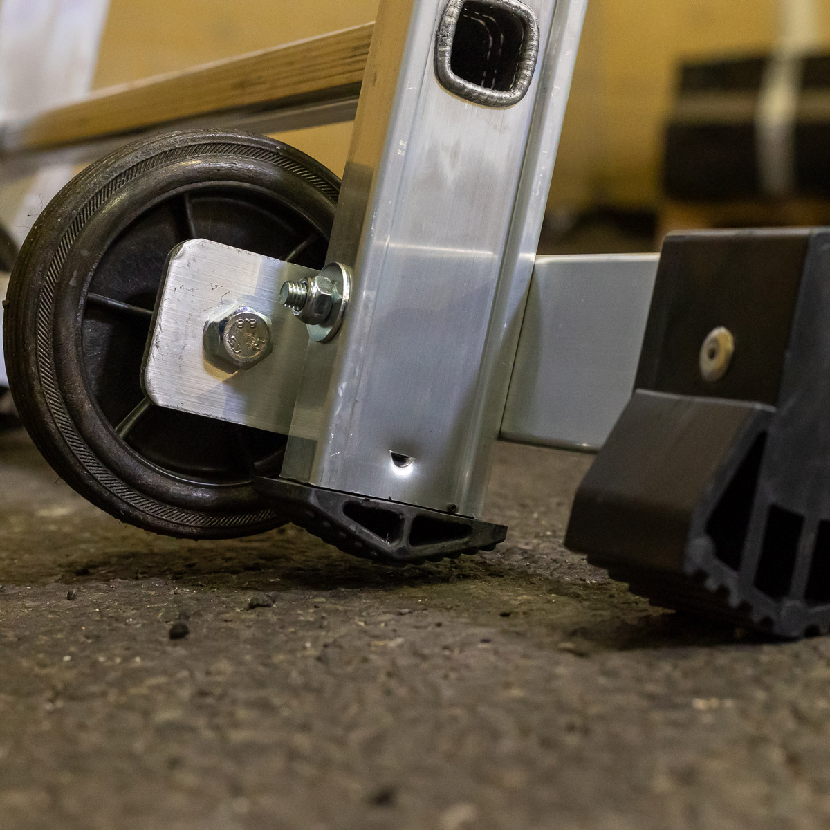 Nærbillede af hjul, stabilisator og skridsikker fod på Moby mobil arbejdsstige
