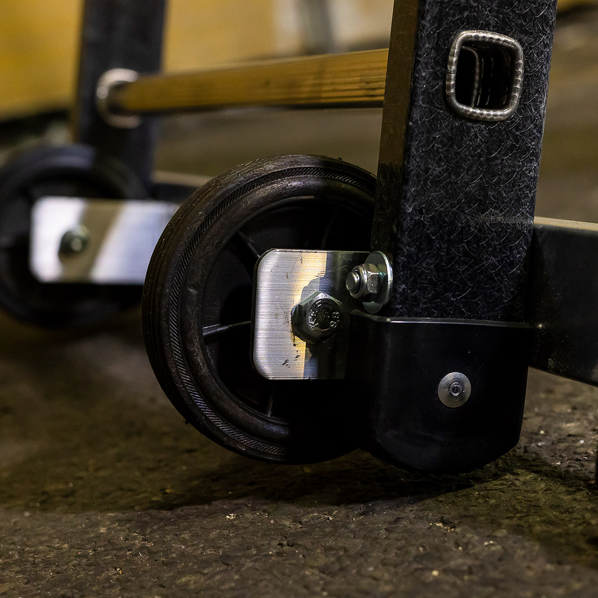Nærbillede af sorte hjul på Moby Fibra platformstige i glasfiber samt nederste aluminiumstrin.