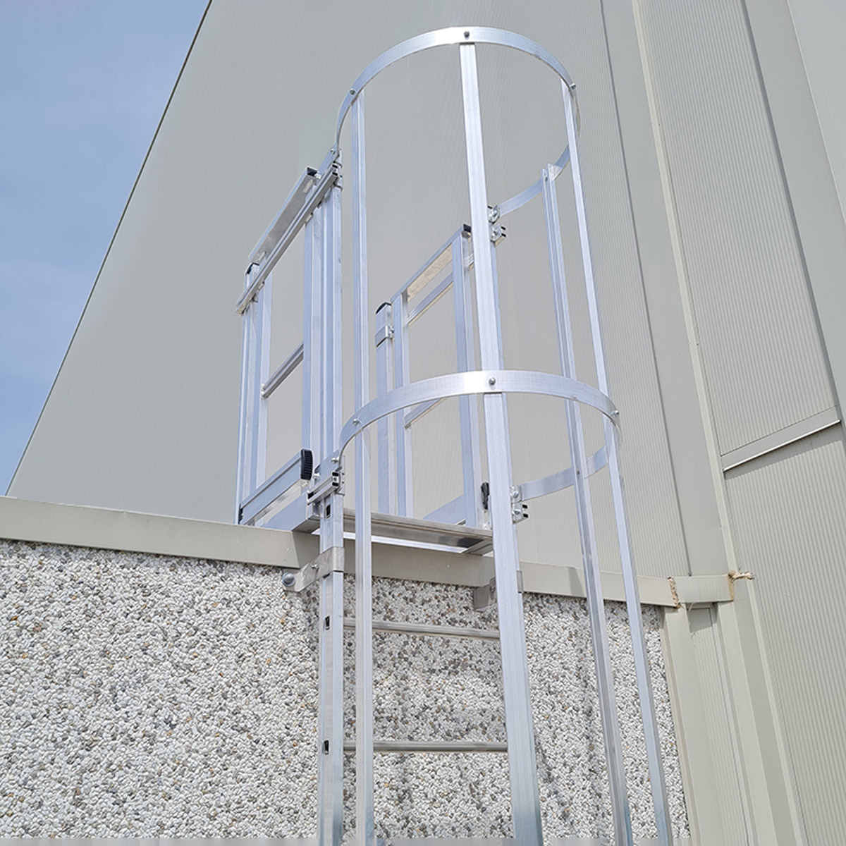 Sidste sektion af vægstige med rygbøjle i aluminium, fotograferet fra lift ved adgang til taget.